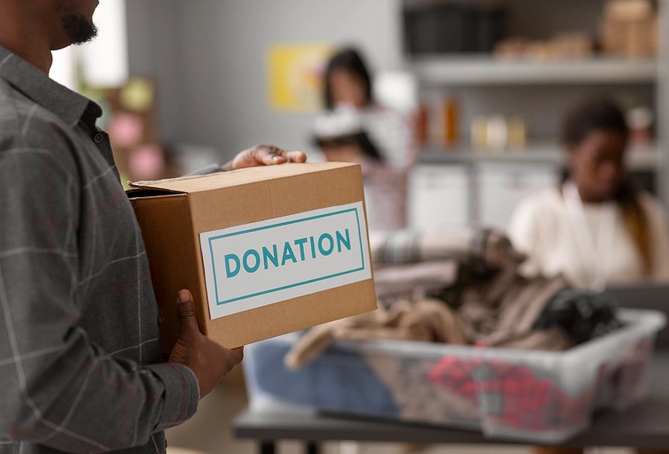 A volunteer holds a donation box, illustrating the community impact achieved through effective non-profit website design and development.