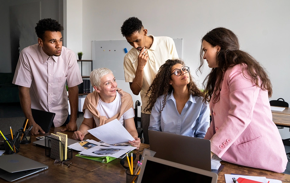 A diverse team of professionals collaborates on mockups and digital strategy for non-profit website design and development.